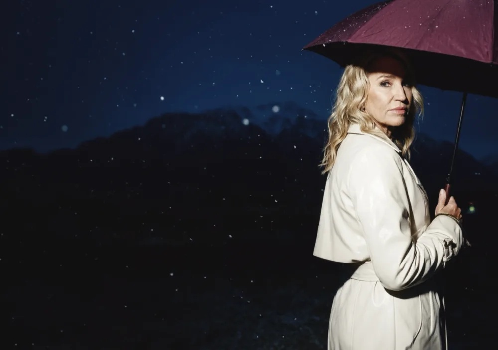 Woman holding an umbrella under a night sky
